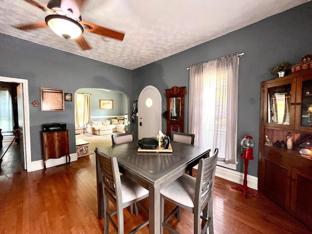 dining space with a textured ceiling, ceiling fan, and dark hardwood / wood-style floors