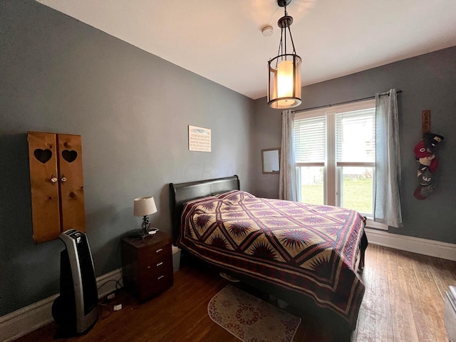 bedroom with dark hardwood / wood-style flooring