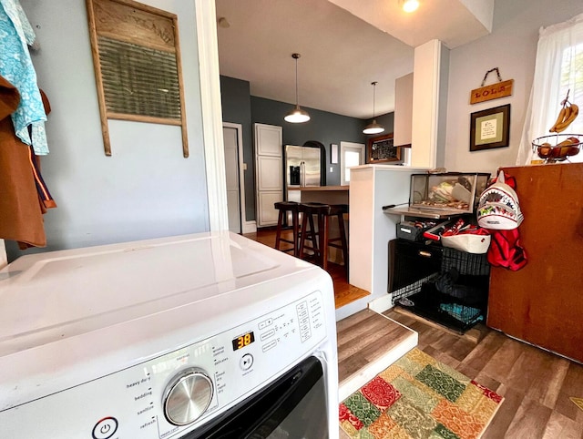 laundry room with washer and clothes dryer and dark hardwood / wood-style flooring