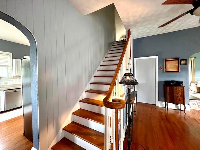 stairway featuring hardwood / wood-style flooring and wood walls