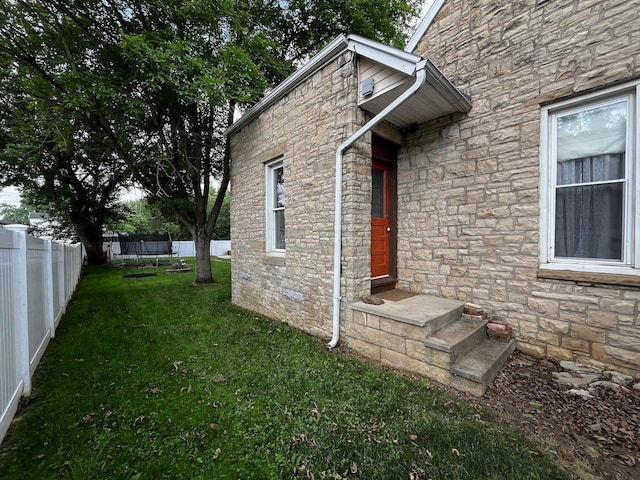 view of exterior entry with a yard