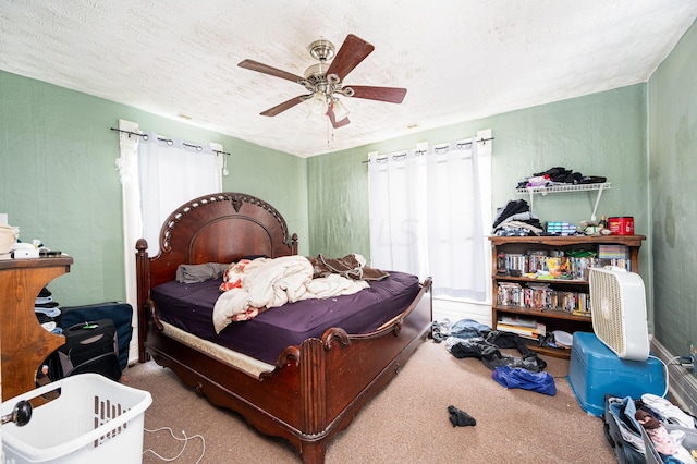 bedroom with ceiling fan, carpet floors, and a textured ceiling