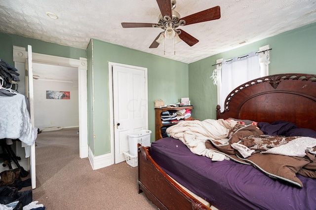 bedroom with ceiling fan, carpet, and a textured ceiling