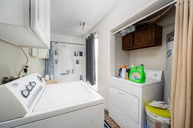 laundry area featuring wood-type flooring, cabinets, and independent washer and dryer