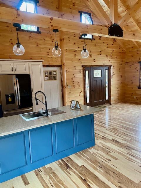 kitchen with pendant lighting, stainless steel fridge, sink, and a wealth of natural light