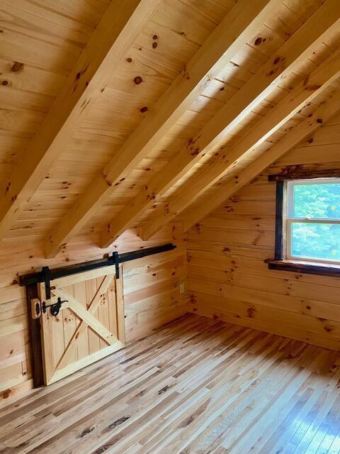 bonus room with vaulted ceiling with beams, hardwood / wood-style flooring, and wooden ceiling