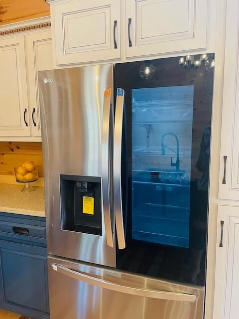 kitchen featuring white cabinets and stainless steel refrigerator with ice dispenser