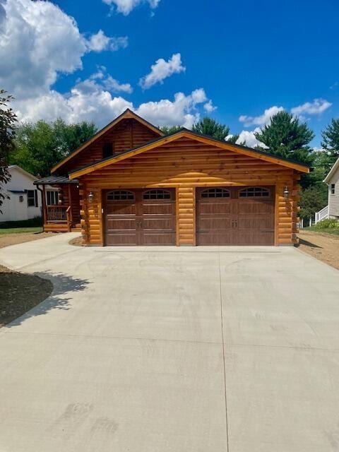 log-style house featuring a garage and an outdoor structure