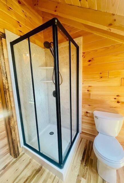 bathroom with toilet, wood walls, hardwood / wood-style floors, and walk in shower