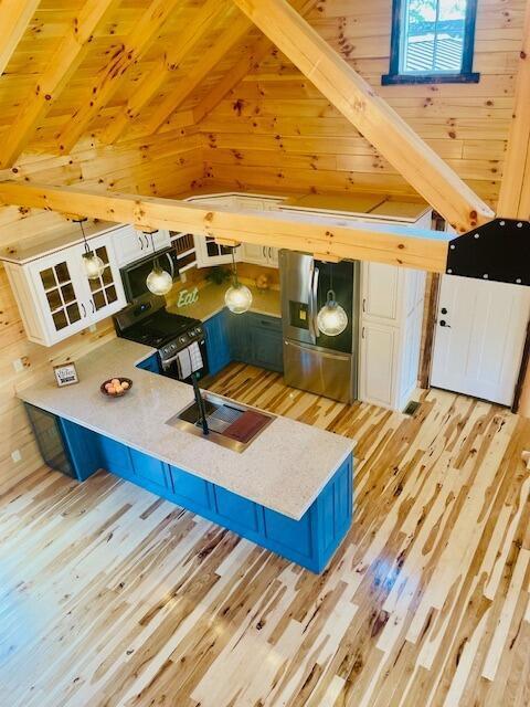 interior space featuring vaulted ceiling, wood walls, light hardwood / wood-style floors, and wooden ceiling