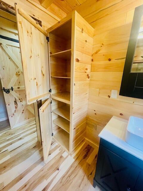 bathroom featuring wood walls, vanity, wood ceiling, and hardwood / wood-style flooring