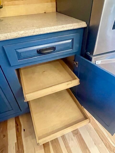 details featuring wood-type flooring and blue cabinets