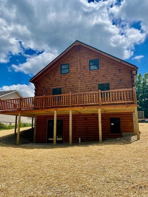 rear view of property featuring a wooden deck