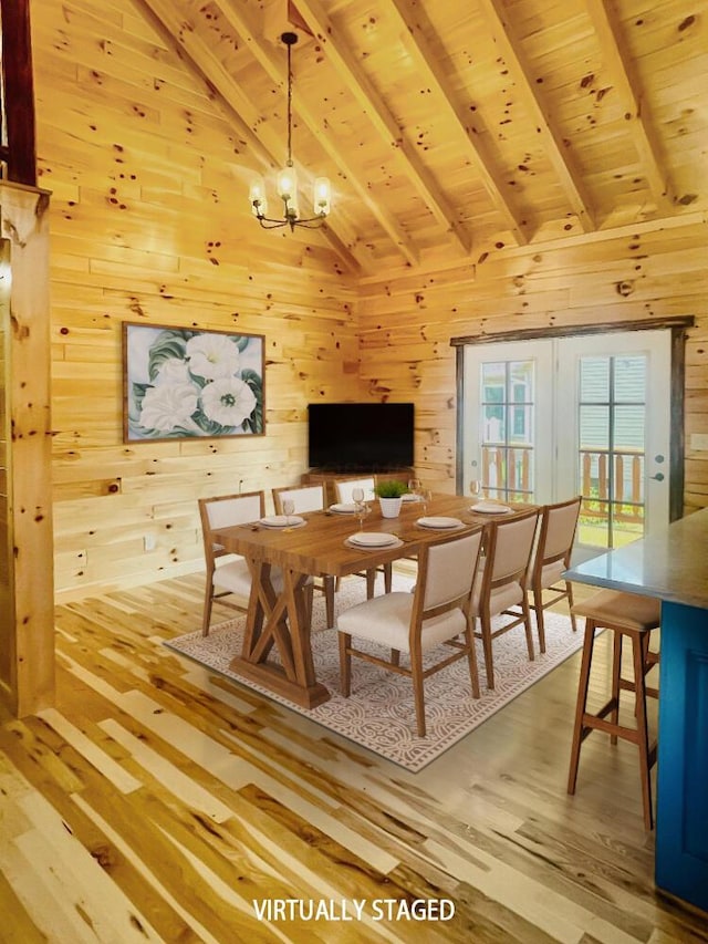 dining area with a chandelier, wood-type flooring, wooden ceiling, and wood walls