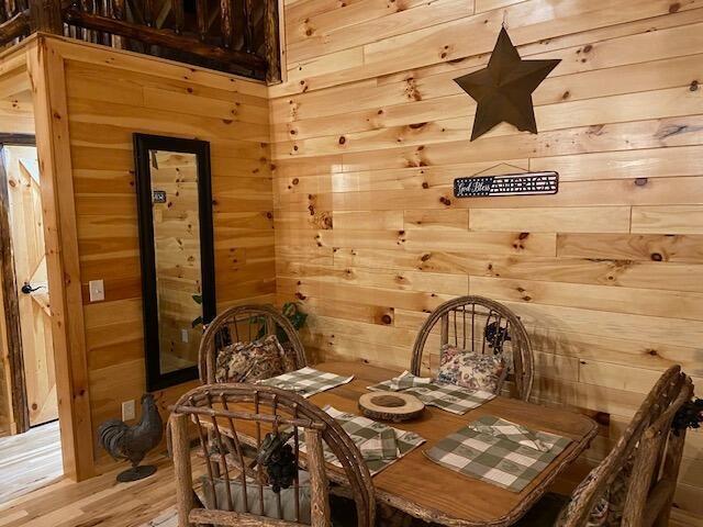 dining area with wood walls and light wood finished floors