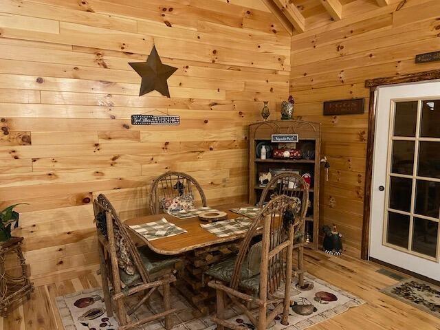 dining room with wood walls and wood finished floors