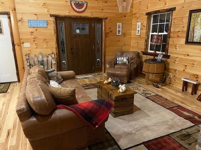 living room with wood finished floors and wooden walls