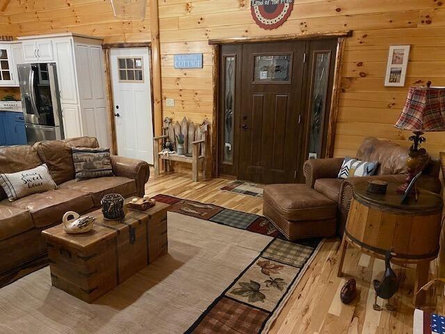 living area with wood walls and light wood-style floors