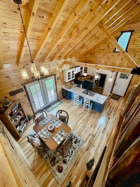 dining area featuring wooden walls, a chandelier, and wooden ceiling