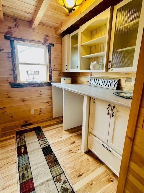 mudroom featuring light wood-type flooring, wood ceiling, beam ceiling, and wooden walls