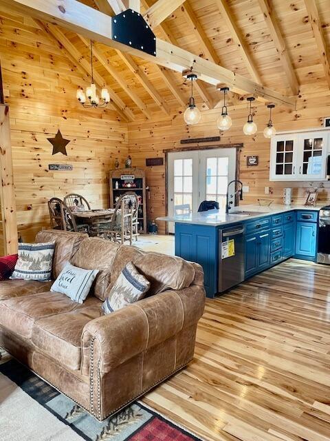 living room featuring light wood-type flooring, wood walls, wooden ceiling, and beamed ceiling