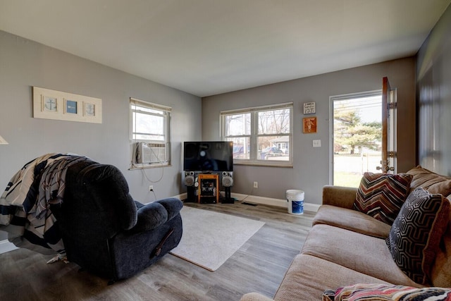 living room featuring light wood-type flooring, plenty of natural light, and cooling unit