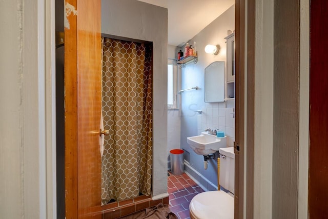 bathroom with curtained shower, tile walls, and toilet