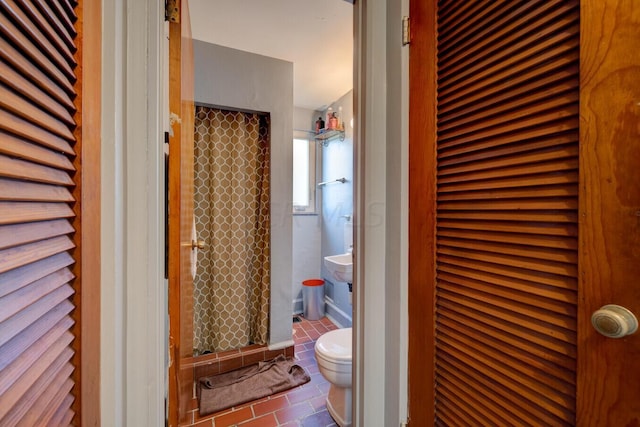 bathroom with curtained shower, tile patterned flooring, and toilet