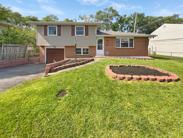 tri-level home with a garage and a front lawn