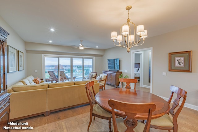 dining room featuring ceiling fan with notable chandelier and light hardwood / wood-style flooring