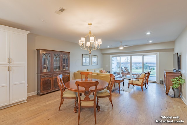 dining area with ceiling fan with notable chandelier and light wood-type flooring