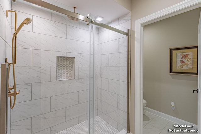 bathroom featuring toilet and a shower with shower door