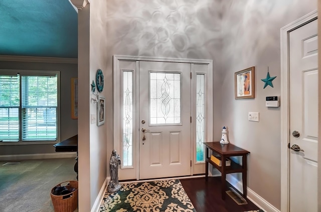 foyer with dark hardwood / wood-style floors and ornamental molding