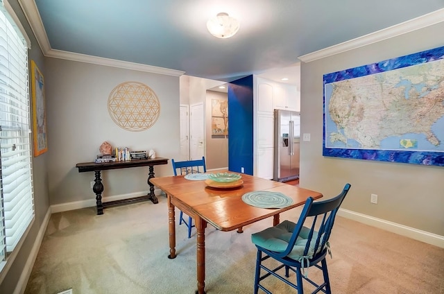 carpeted dining room with a healthy amount of sunlight and ornamental molding