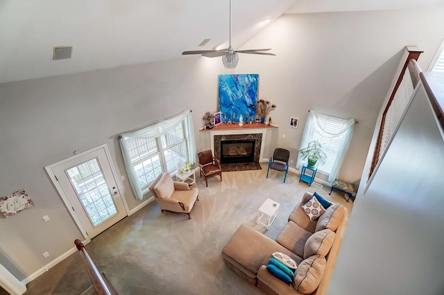 carpeted living room with ceiling fan, a premium fireplace, and high vaulted ceiling