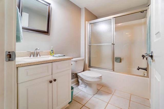 full bathroom with shower / bath combination with glass door, tile patterned flooring, vanity, and toilet