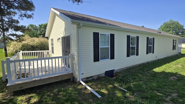 view of property exterior with a deck and a yard