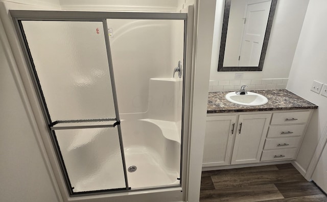 bathroom featuring vanity, wood-type flooring, and an enclosed shower