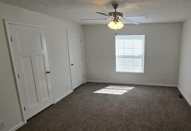 carpeted empty room featuring a textured ceiling and ceiling fan