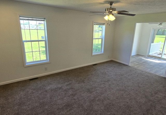 carpeted spare room featuring ceiling fan and a textured ceiling