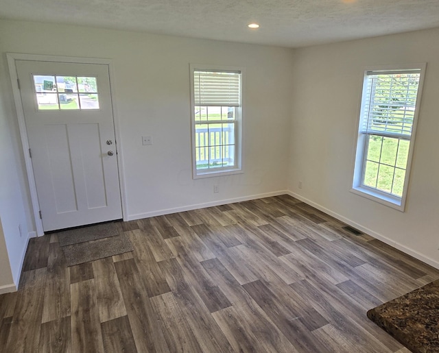 entrance foyer with hardwood / wood-style floors and a textured ceiling