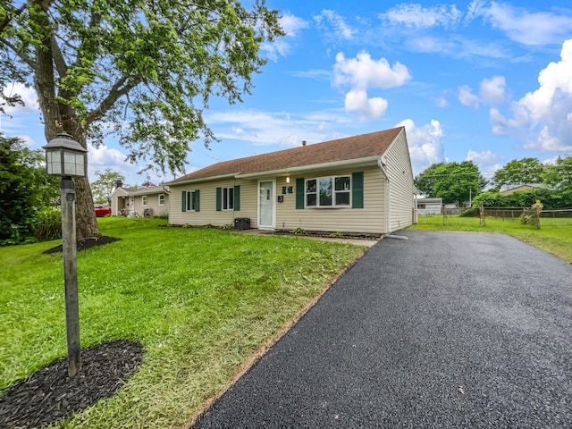 view of front of property with central AC and a front lawn