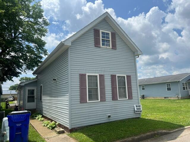 view of side of home with a yard