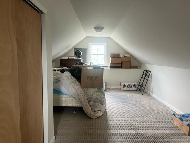 carpeted bedroom with vaulted ceiling