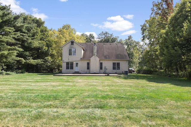 back of property with central AC, a yard, and a patio