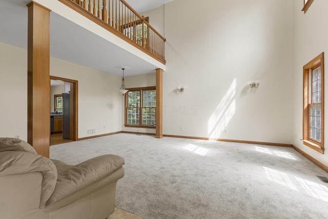 living room with a towering ceiling and light carpet