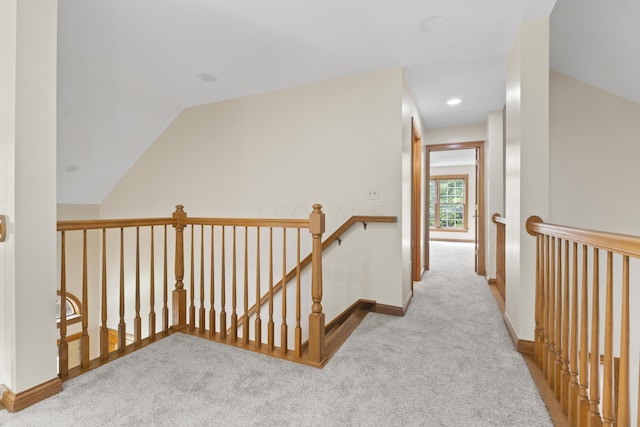 hallway with light carpet and lofted ceiling