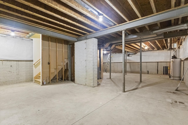 basement with gas water heater and brick wall