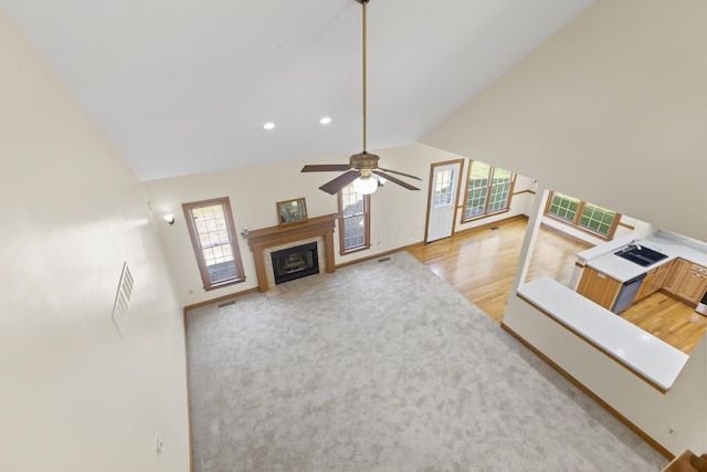 living room featuring ceiling fan, high vaulted ceiling, and light wood-type flooring