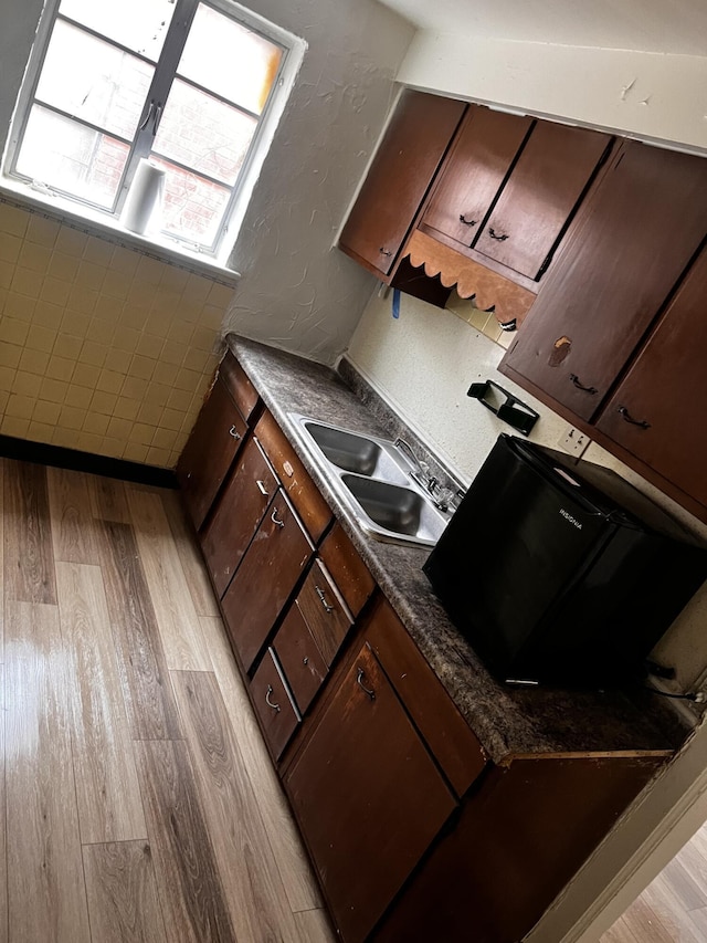 1001 Lilley Ave, Columbus, OH 43206 - kitchen with dark brown cabinetry, sink, and light hardwood / wood-style floors